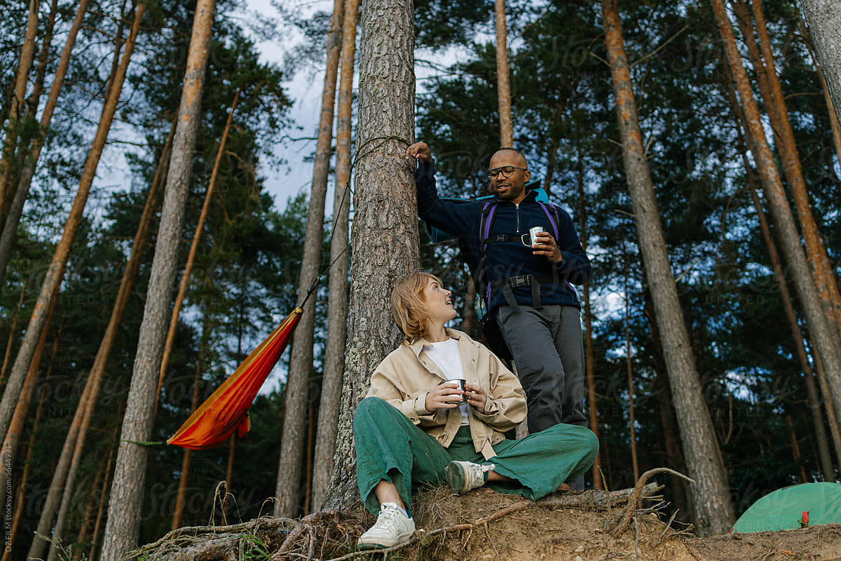 A man and a woman drink tea at a camping