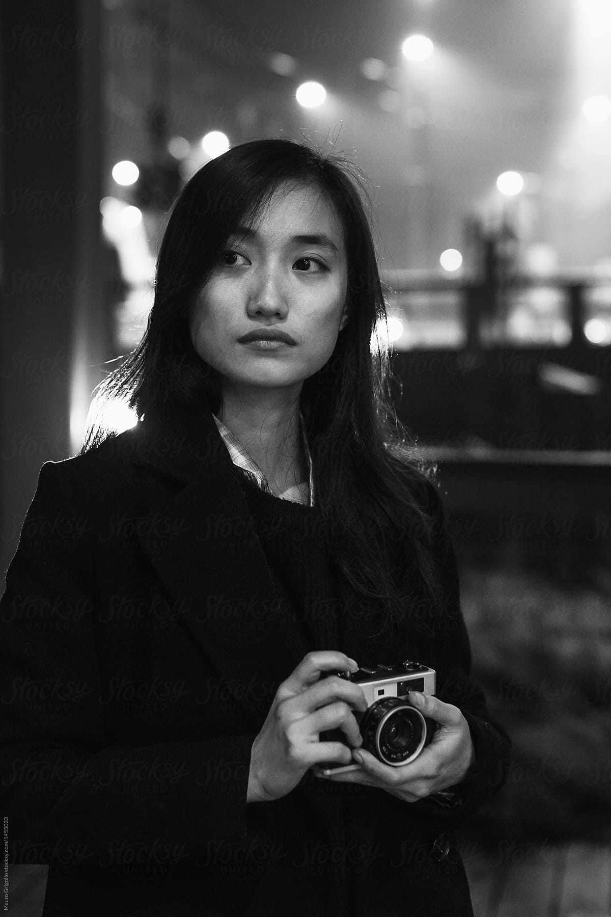 Female Asian photographer in the city at night