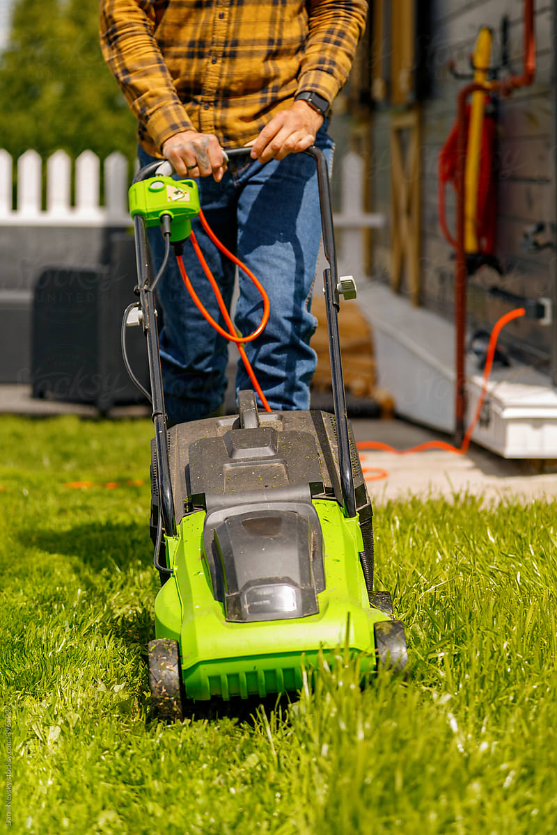 Crop man using electric mower in yard