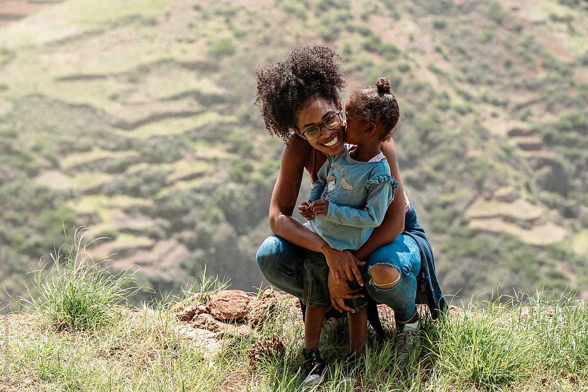 African little girl with mum standing on top of mountain