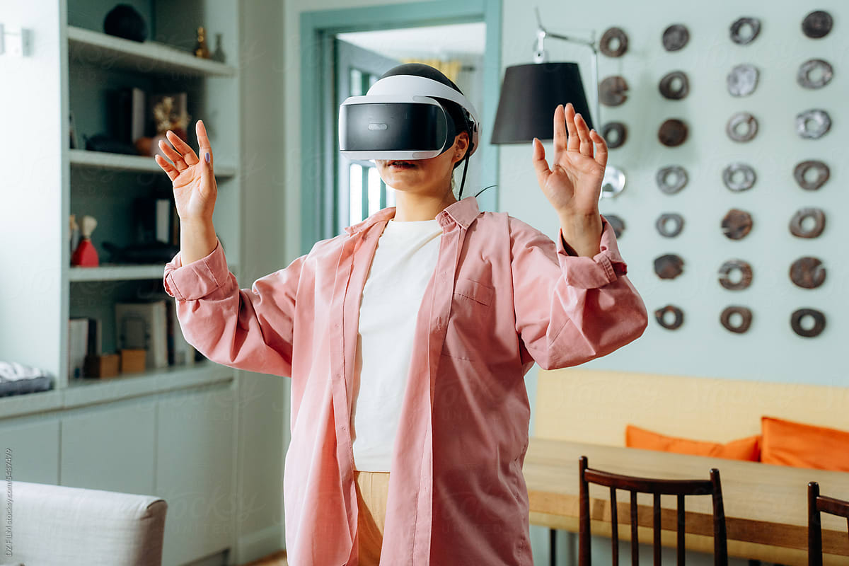 A woman wearing virtual reality glasses at home