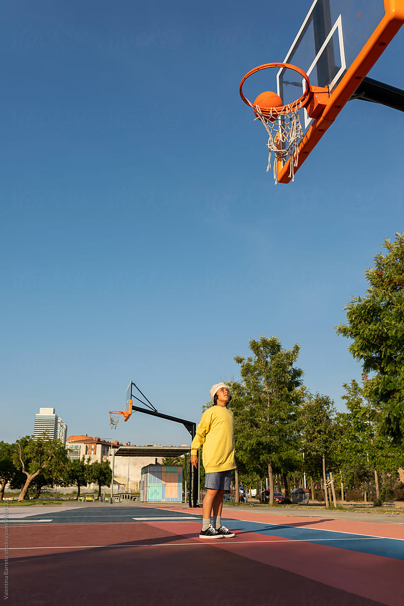 Boy making a basketball shot that skims the hoop