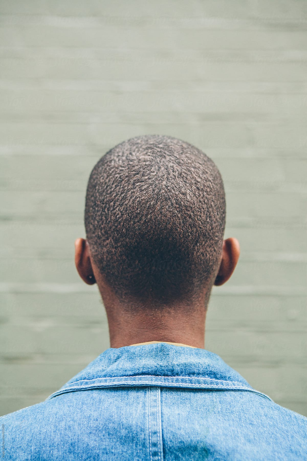 Portrait of a black woman with very short hair photographed from behind
