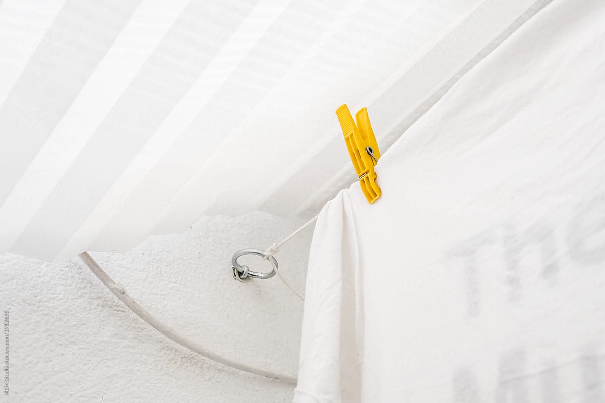 Yellow clothes peg on a white laundry