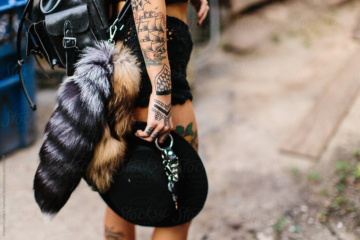 A woman wearing two furry fox tails on her waist