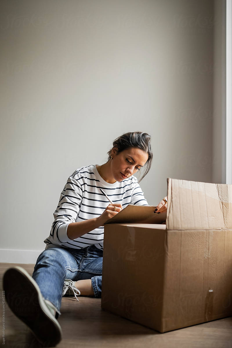 Young woman with a moving box at home