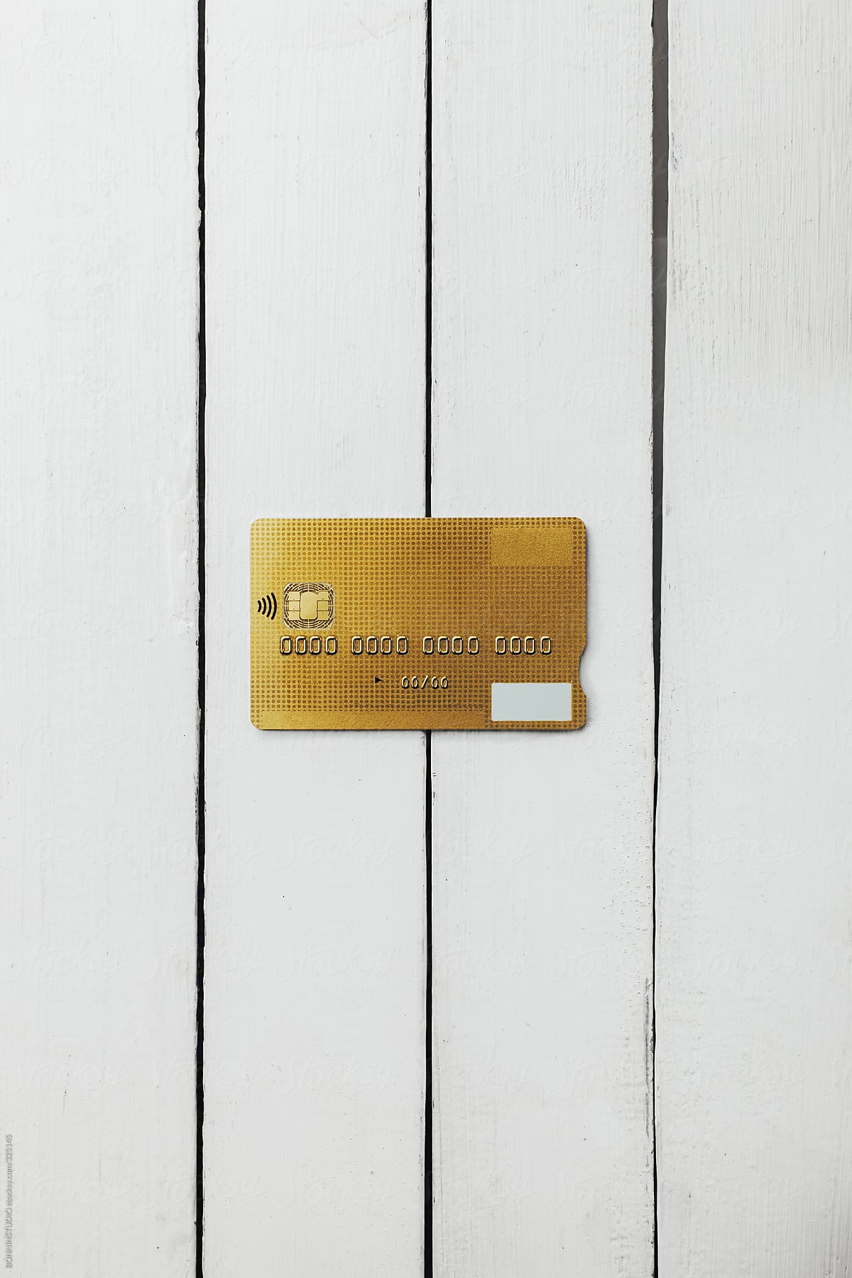 Gold credit card on wooden background.