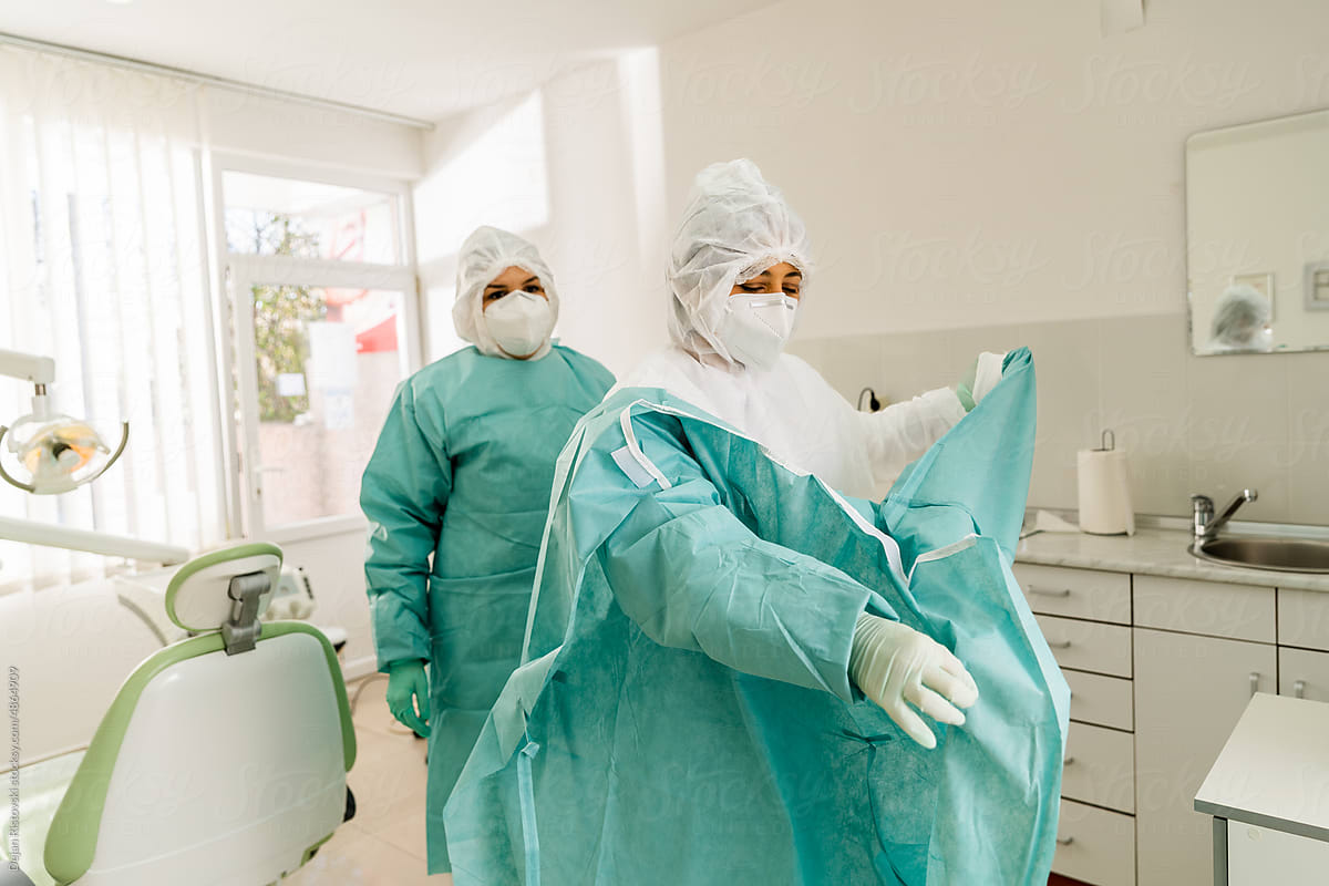 Dentist get dressed with protection equipment