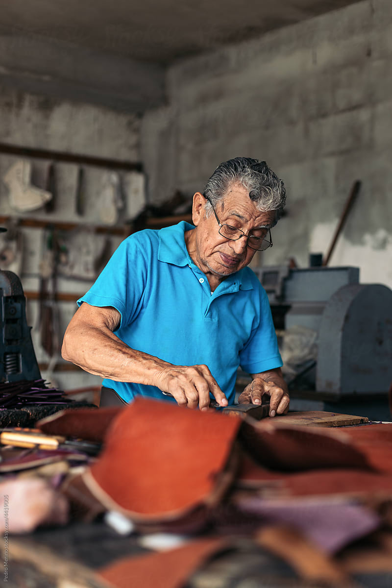 Hispanic senior shoemaker working in his workshop