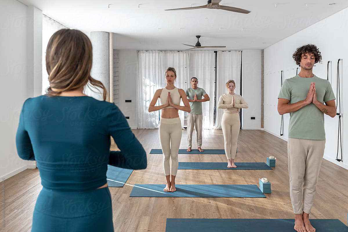 Group meditating with trainer in Tadasana pose