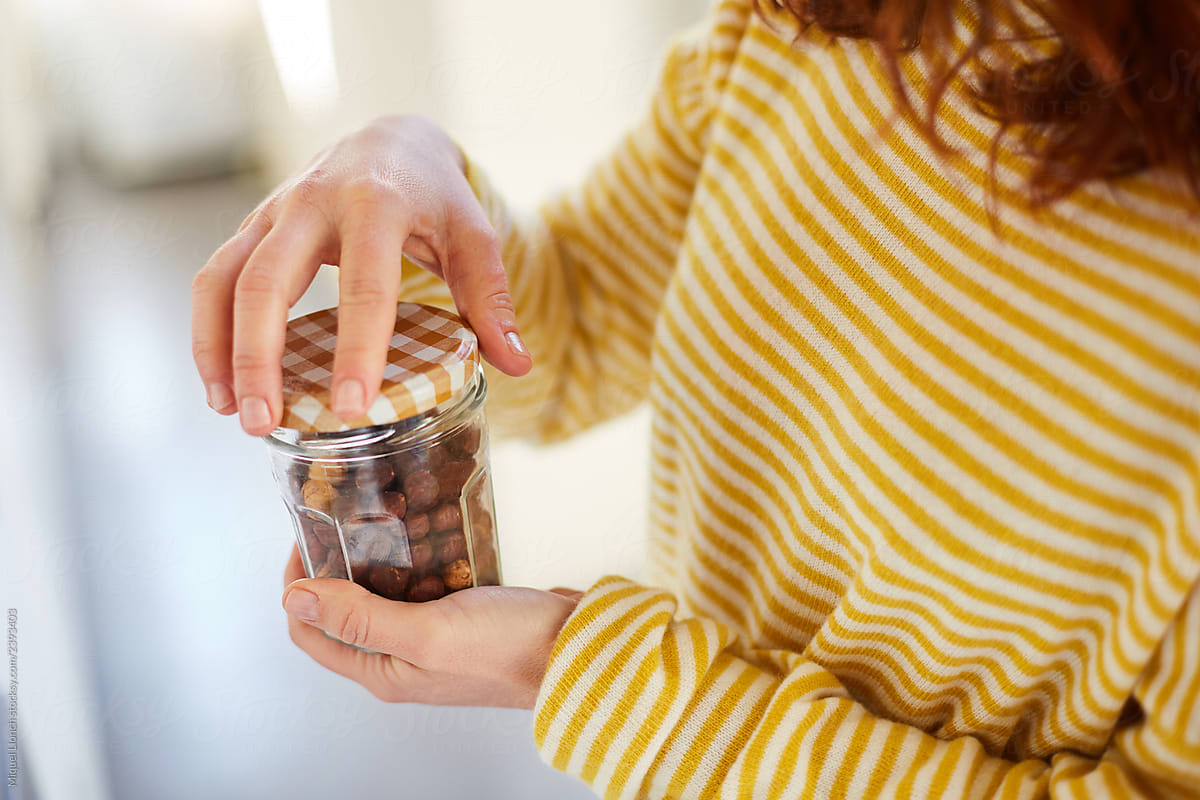 Woman hands holding a jar of hazelnuts