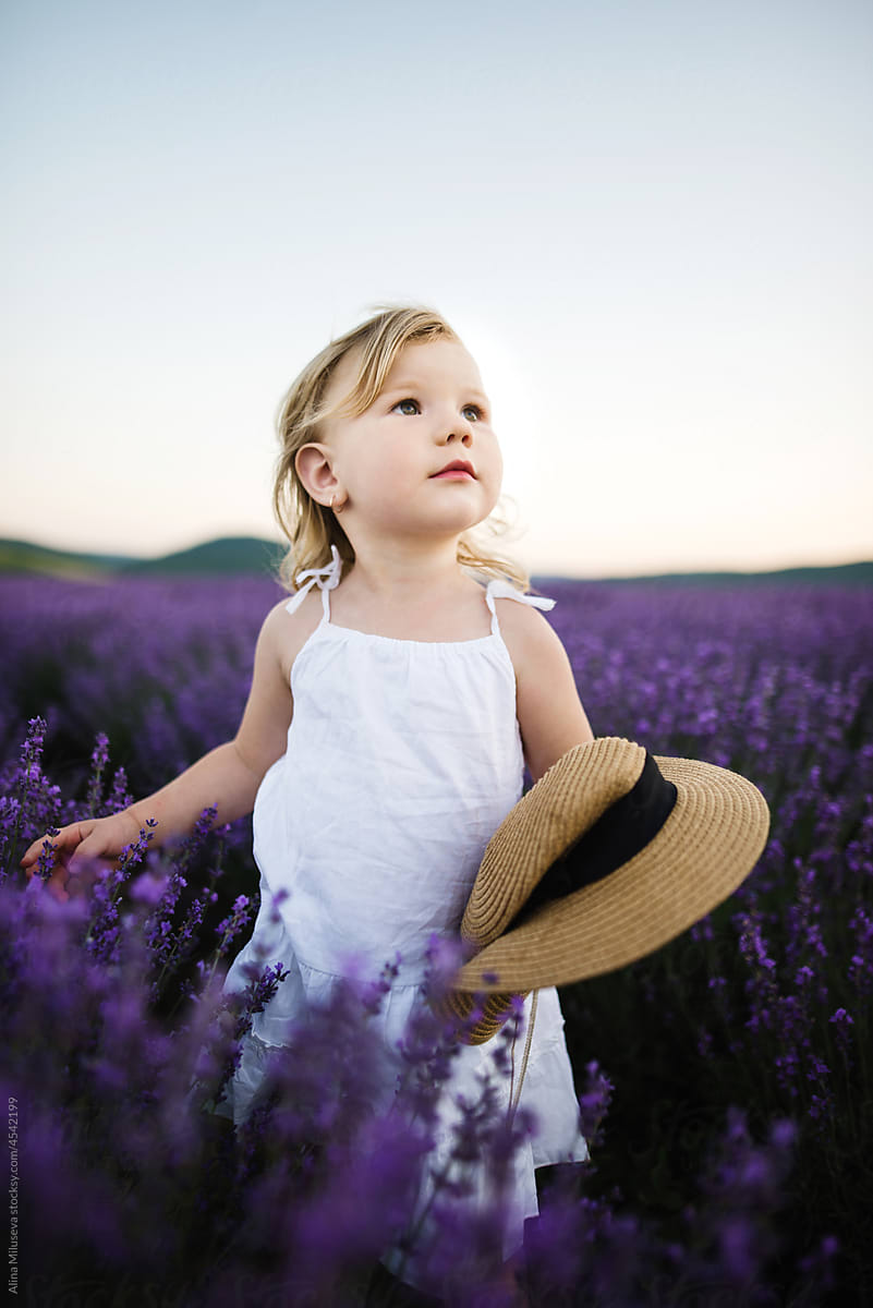 Cute blonde girl in blooming lavender field
