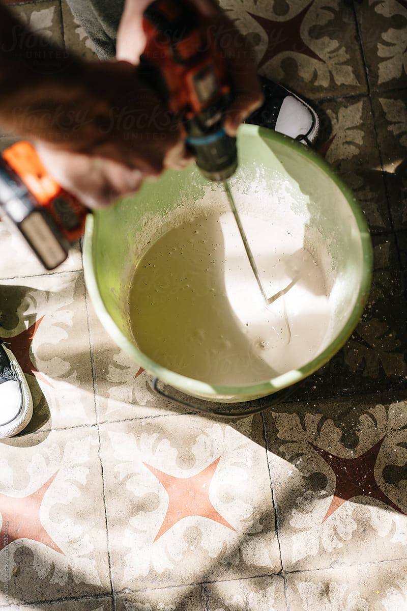Crop craftsman mixing plaster in bucket