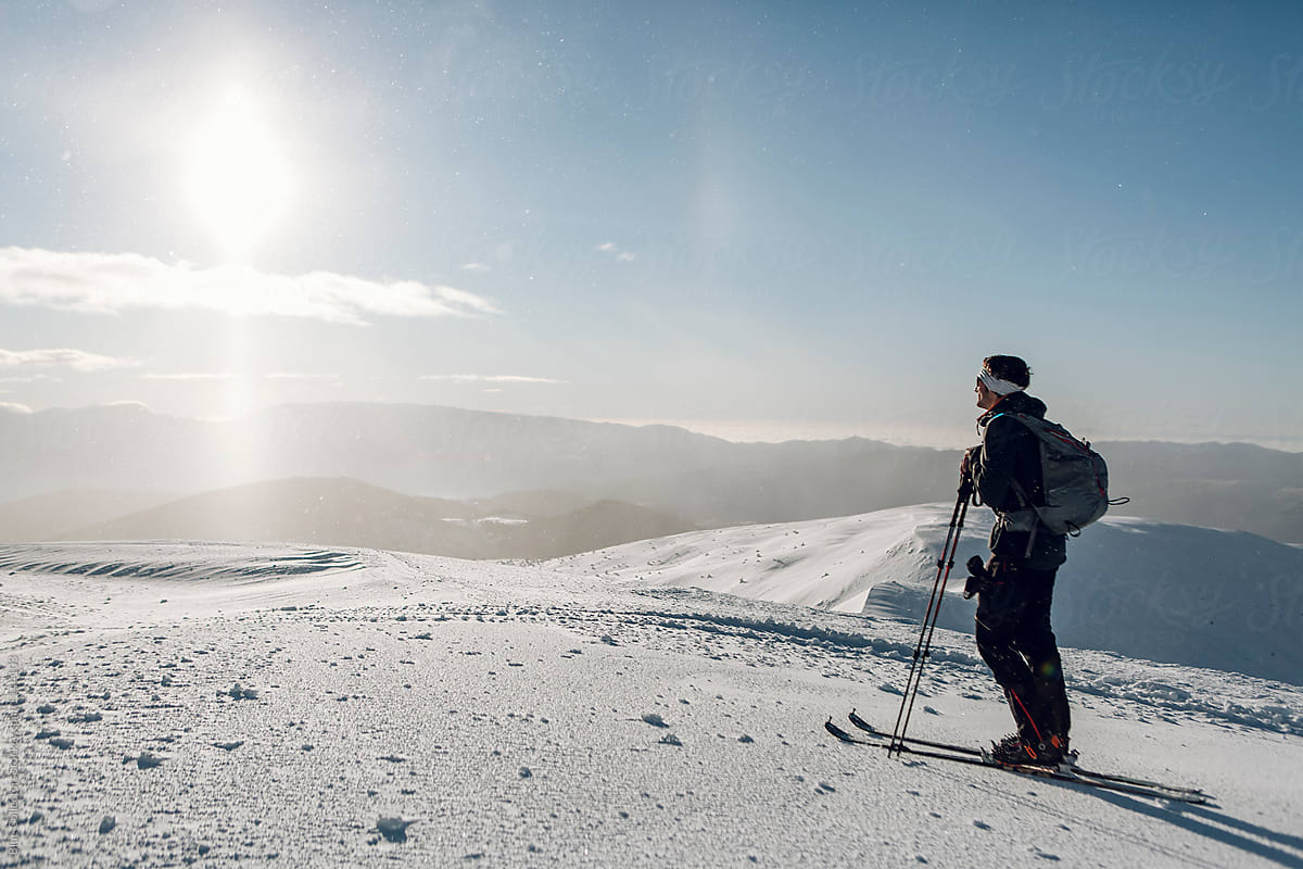 Skier in the top of the mountains on his skis enjoying the sunrise, cross-country skiing