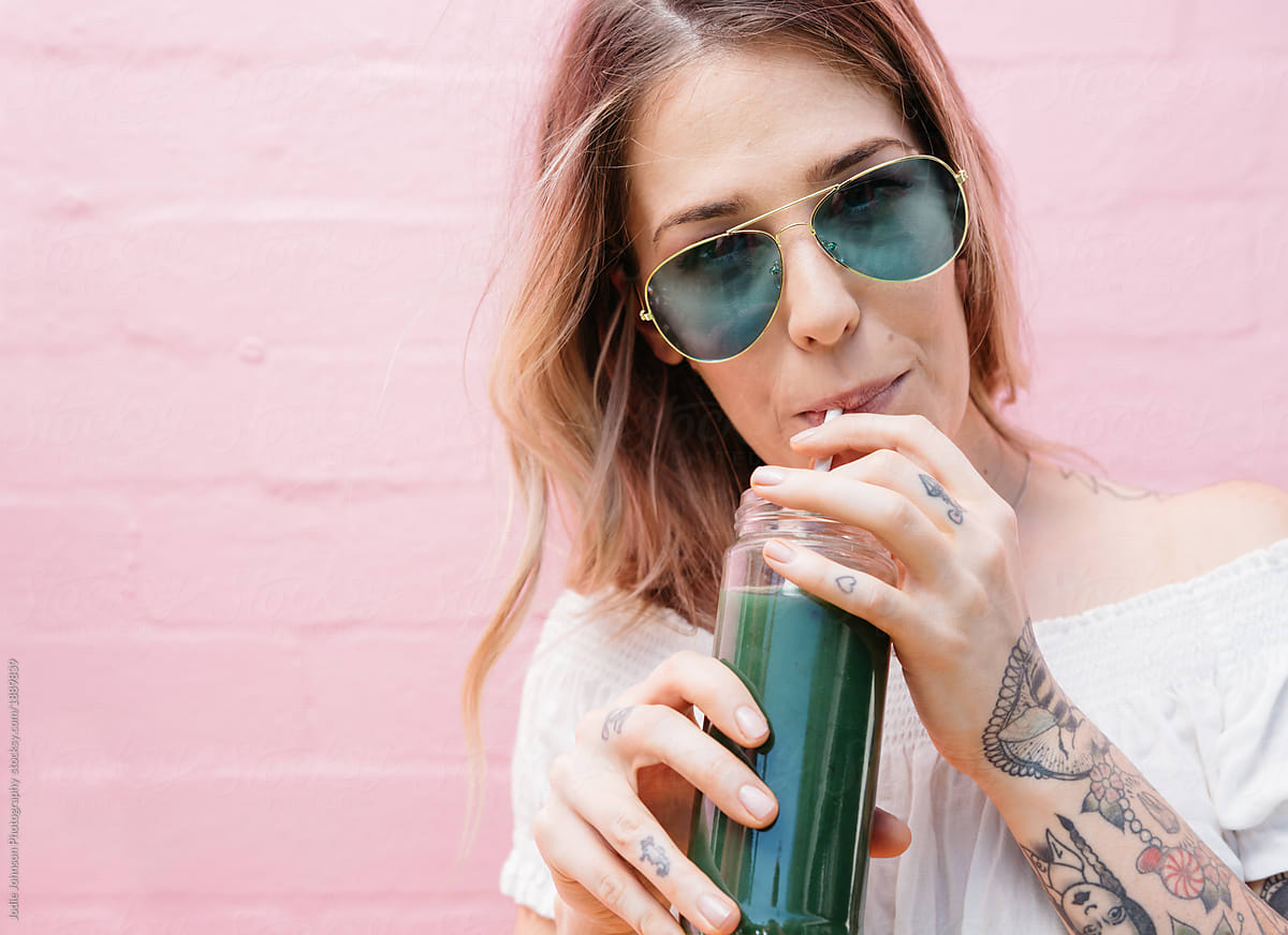 Young woman drinking vegetable juice outdoors