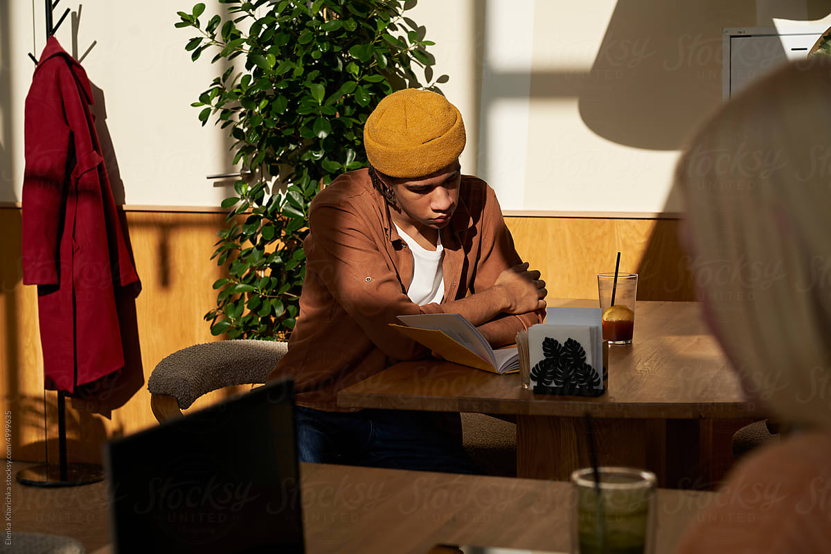 Man reading book resting in cafeteria