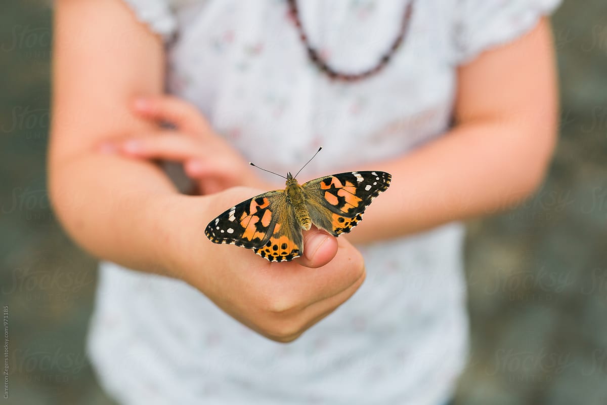young girl releasing butterfly