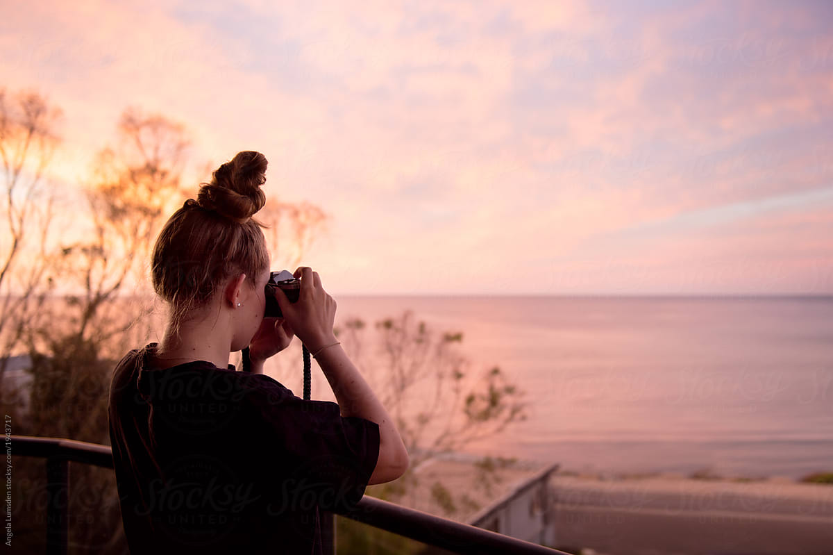 Teenage Girl Taking Photos Of A Sunset At The Beach By Stocksy Contributor Angela Lumsden