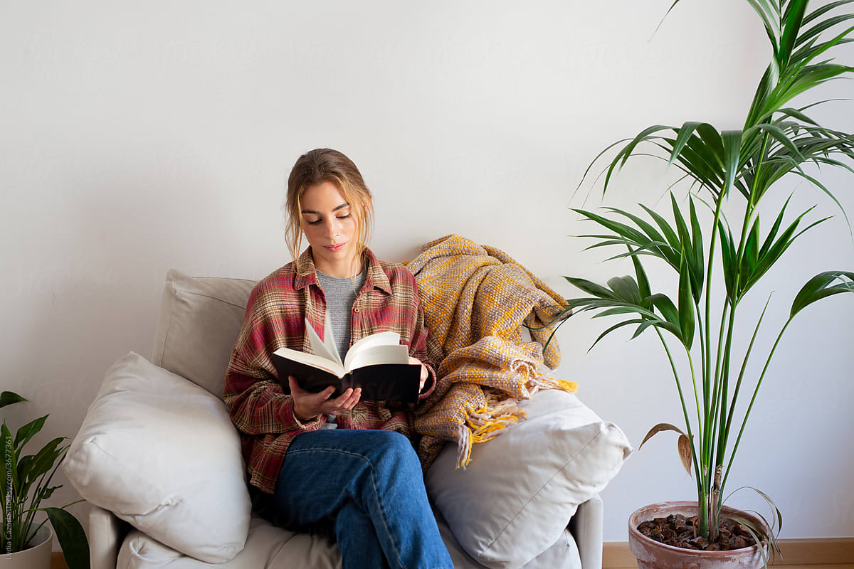Young woman reading a book in sofa