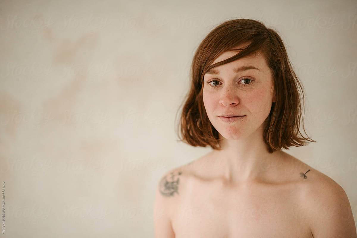 Shirtless tattooed gentle young woman