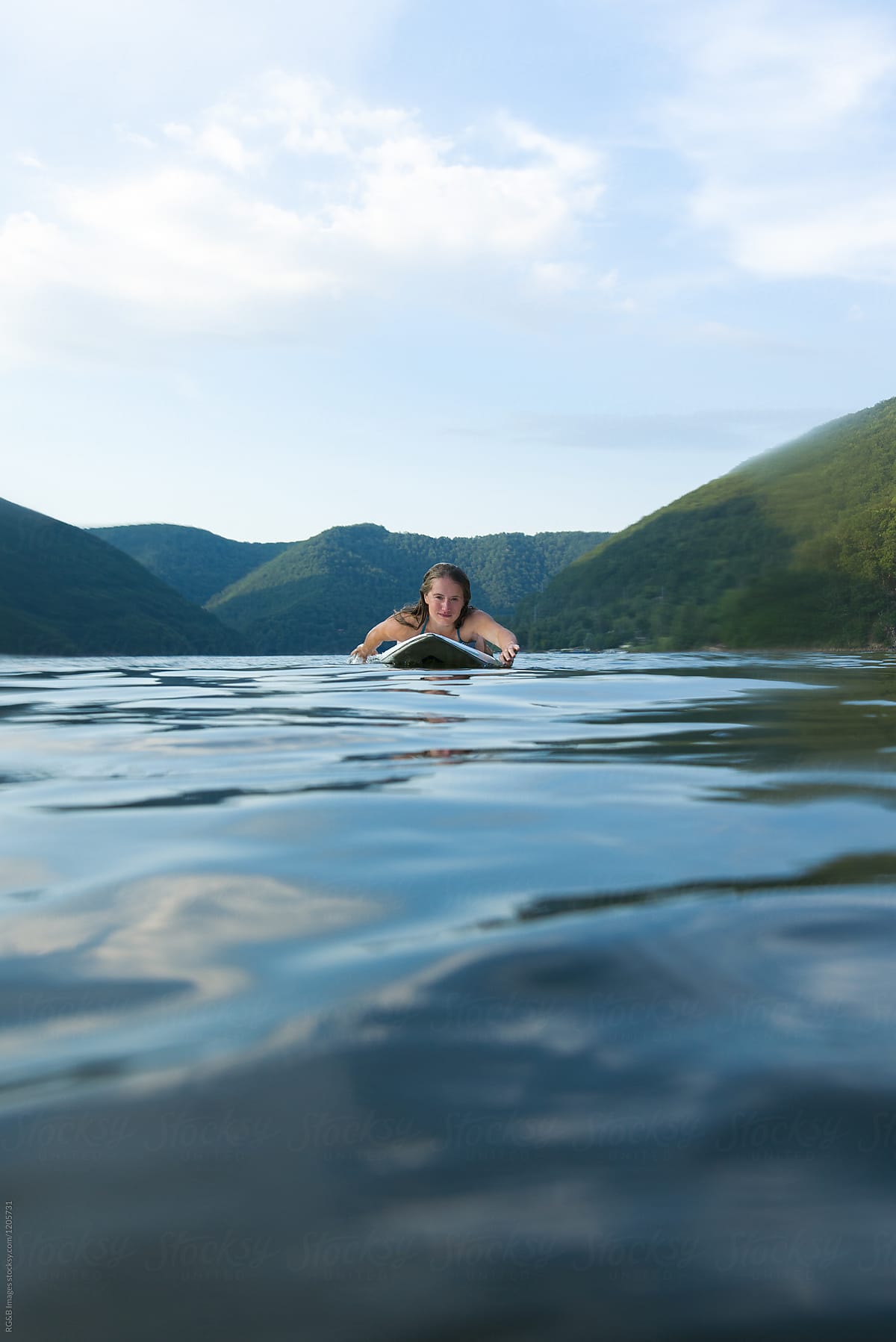 Woman floating in the middle of a lake on summertime