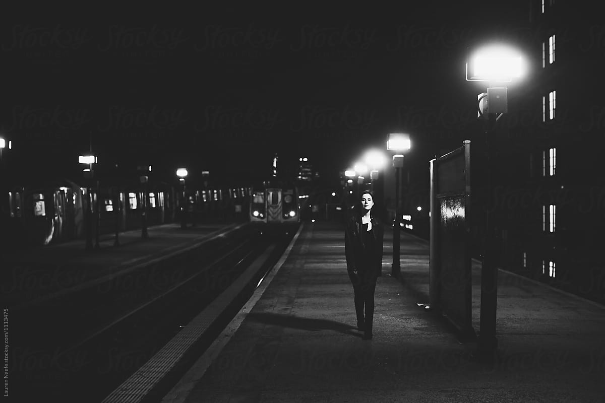 Woman walking in train station at night
