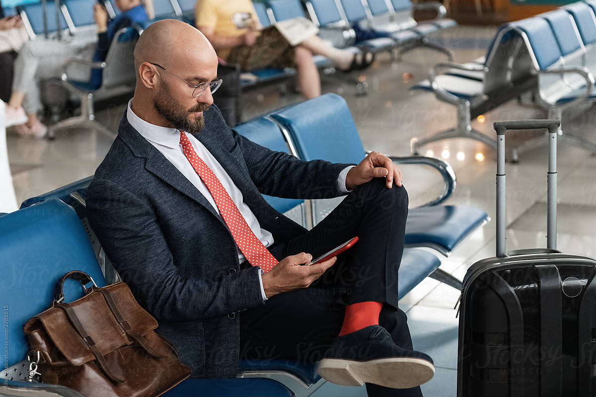 Confident businessman messaging on smartphone in airport