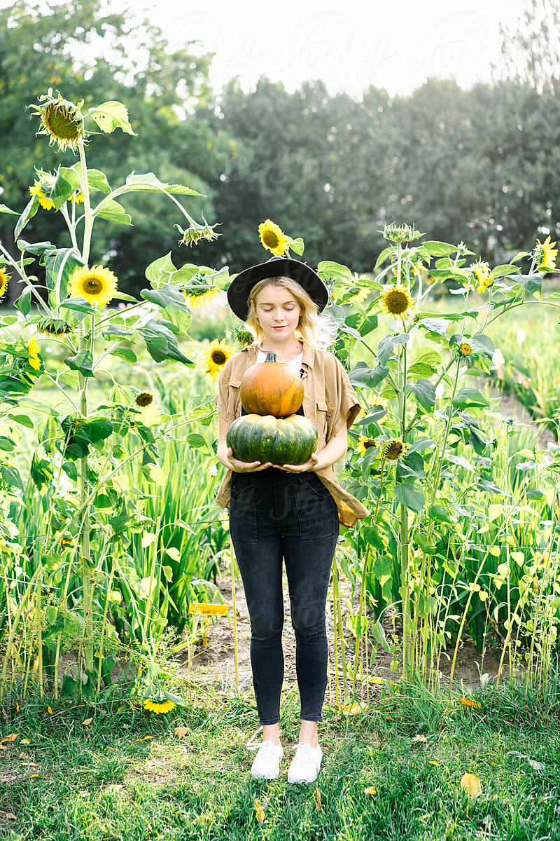 Woman with pumpkins in green field