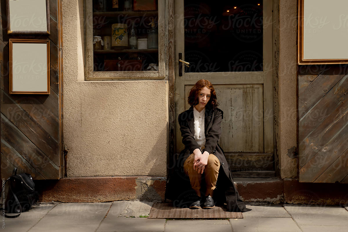 Woman Sitting By Vintage Grocery Store