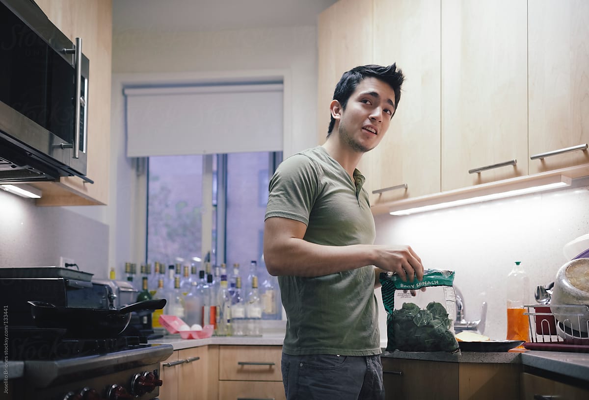 Hispanic - Latino Young Male Student with Spinach in Kitchen of New York Apartment