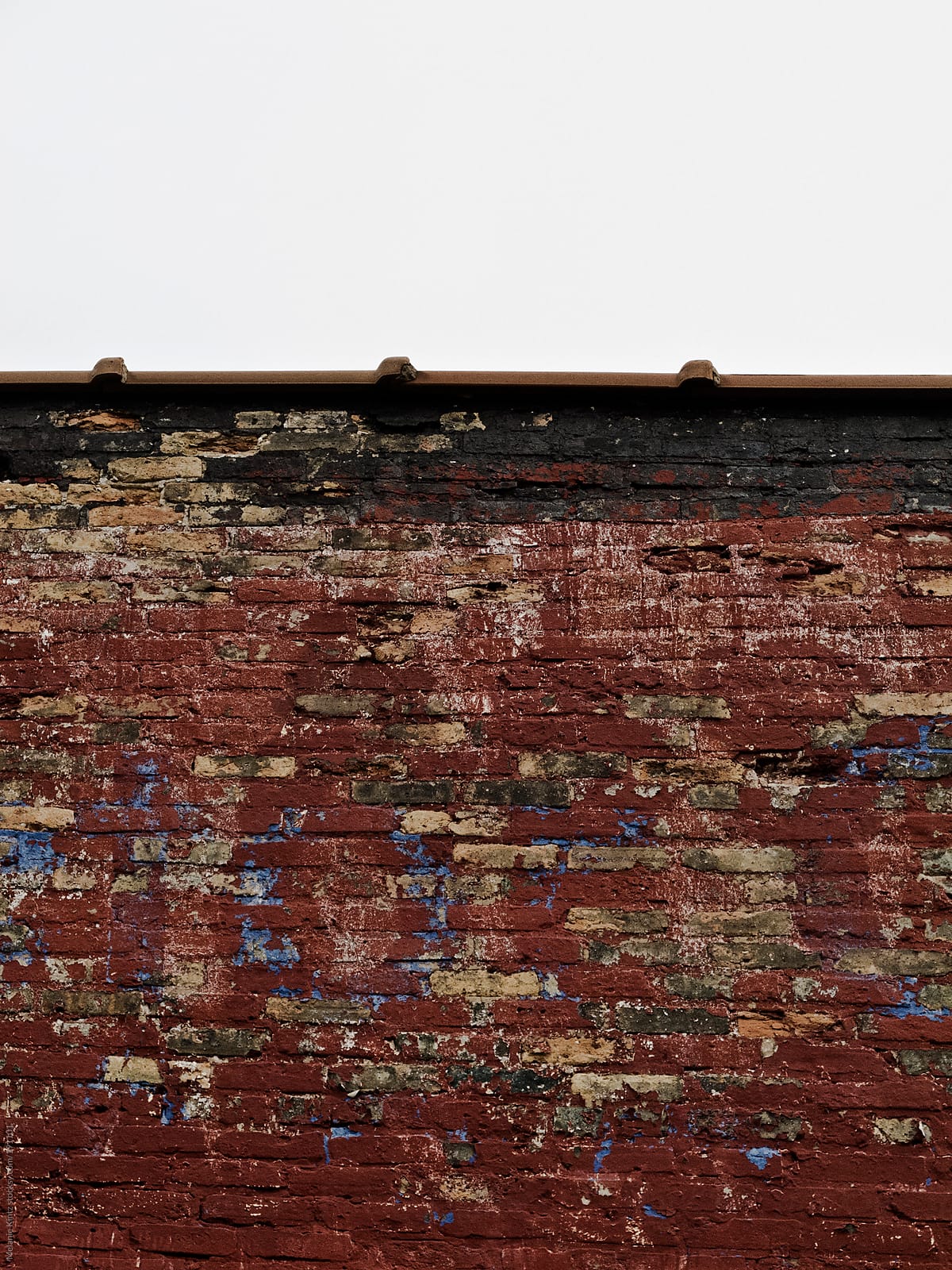 Brickwall with different layers of paint showing