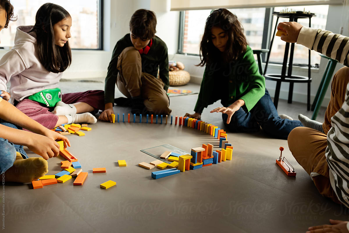 Kids playing with dominoes at playroom floor