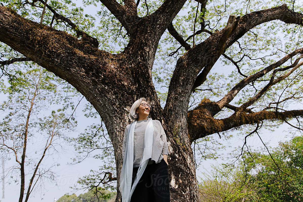 Mature woman  standing under tree