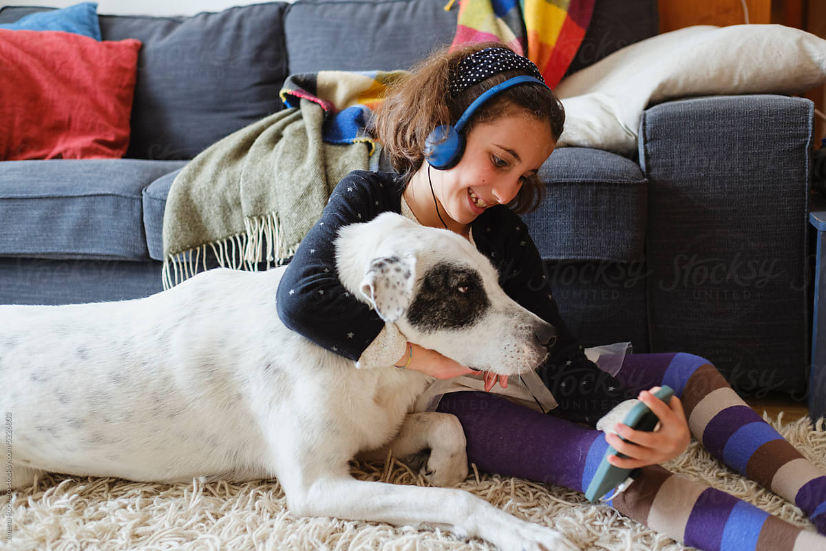 Kid at home showing her dog to video chat on smartphone