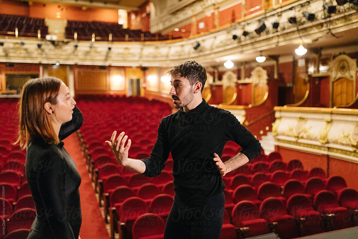 Dancers talking during rehearsal in theatre