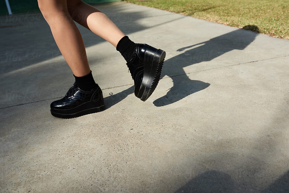 Fashionable woman\'s shoes walking on asphalt.