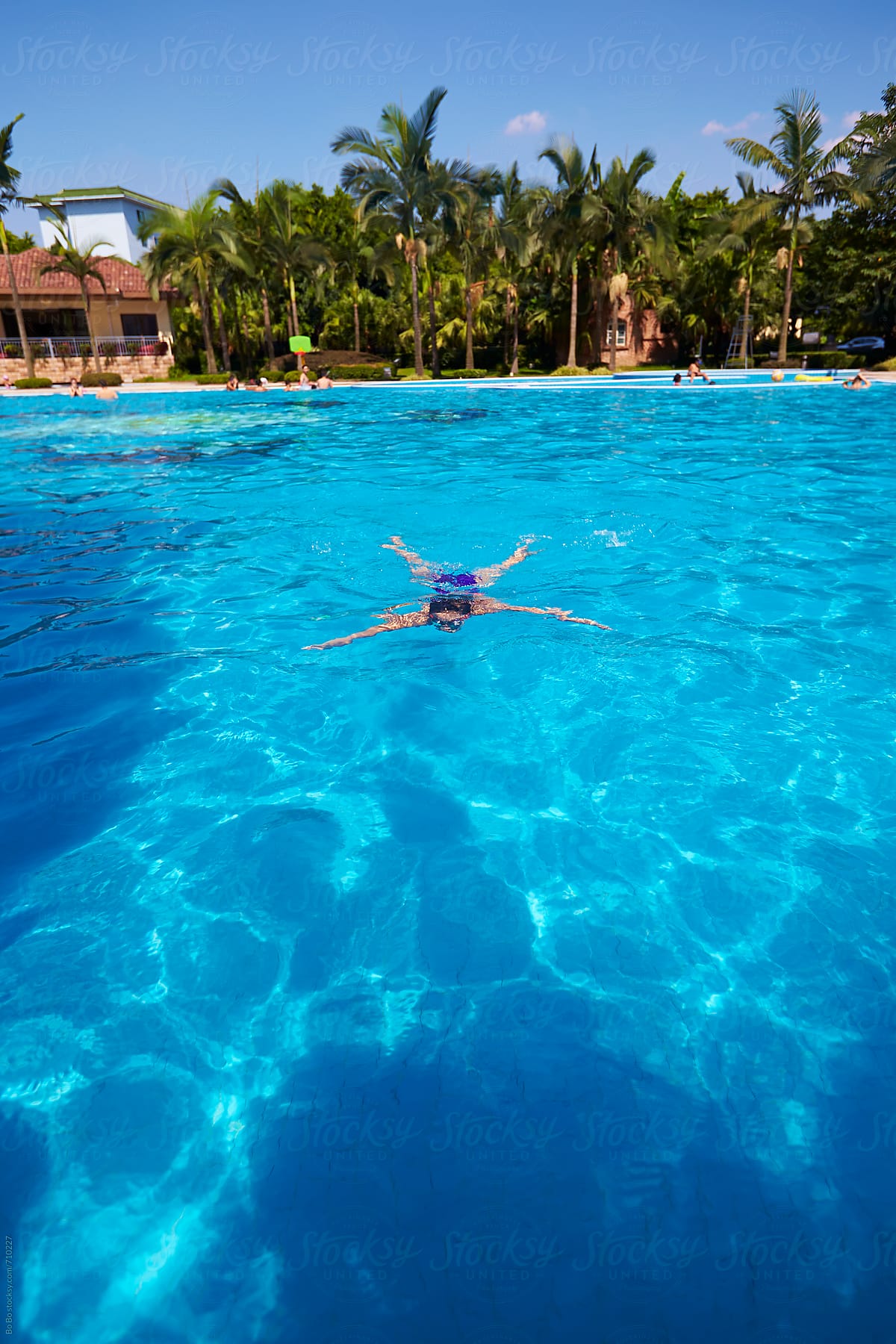 little asian girl swimming in beautiful swimming pool