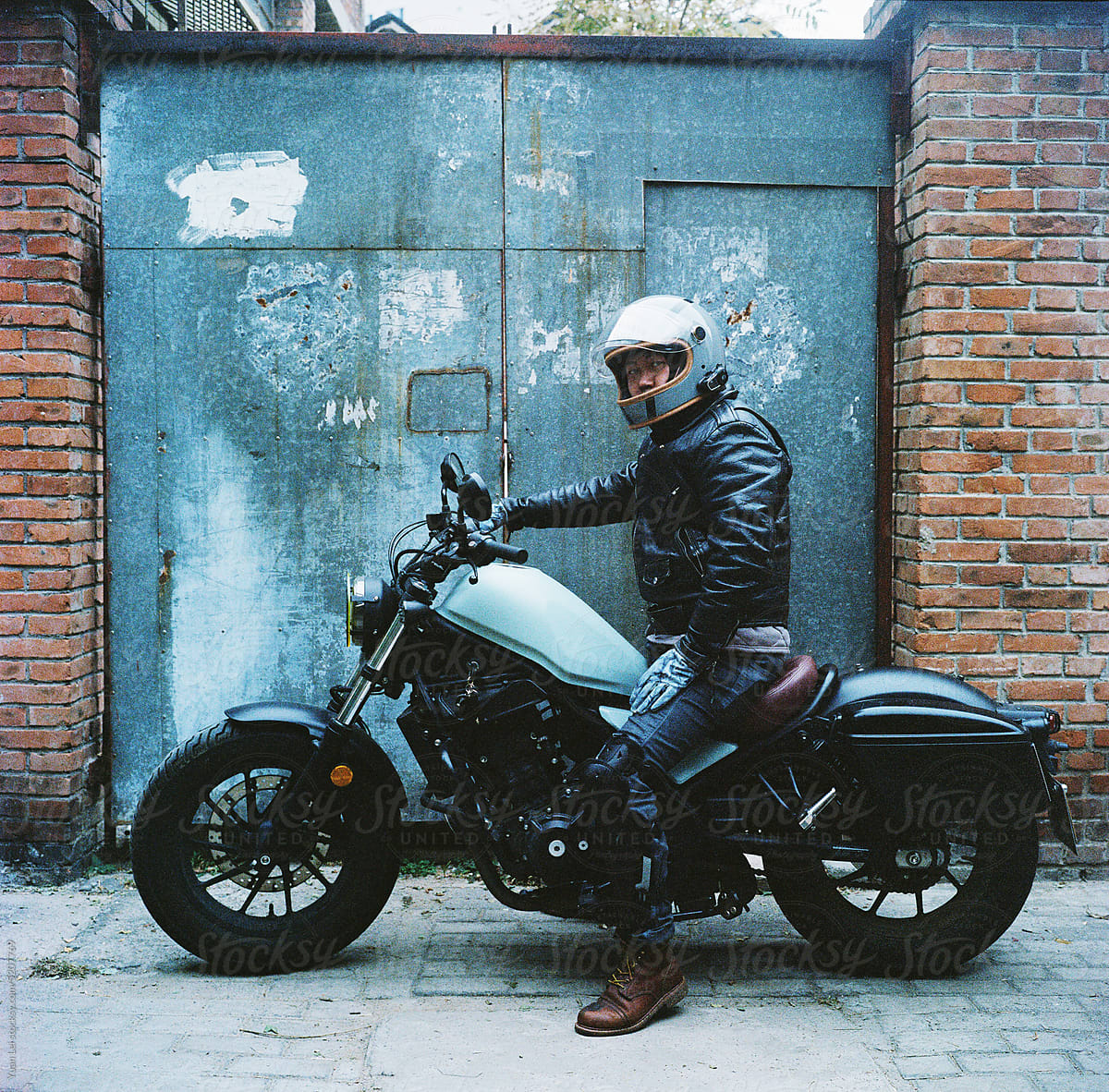 A man in black leather on a motorcycle.