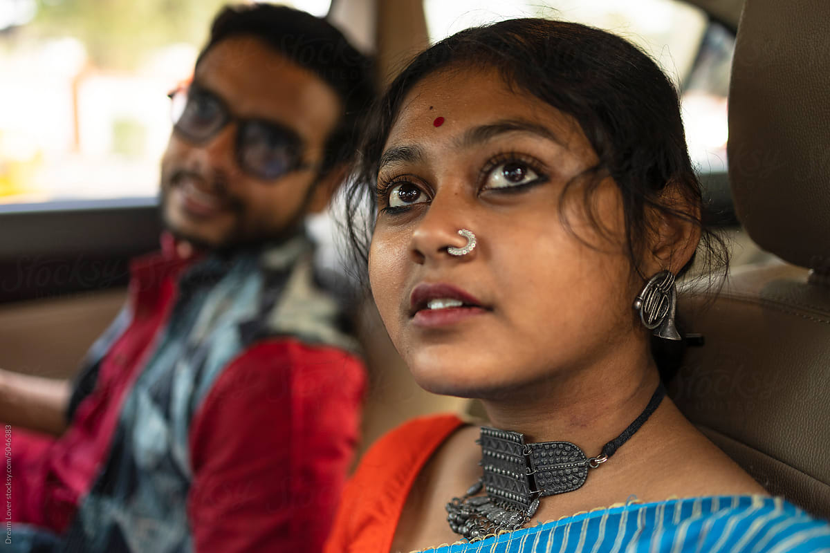 Young couple interacting inside a car wearing traditional Indian dress