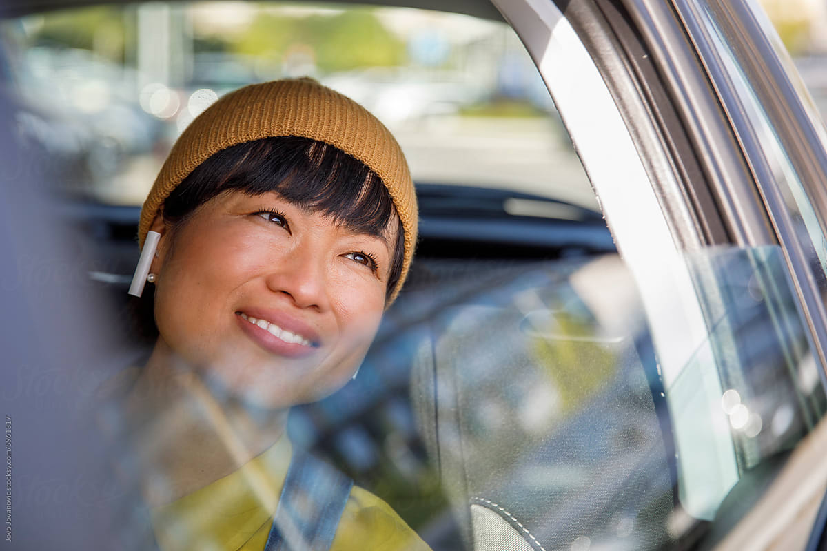 Thoughtful smiling woman traveling in car