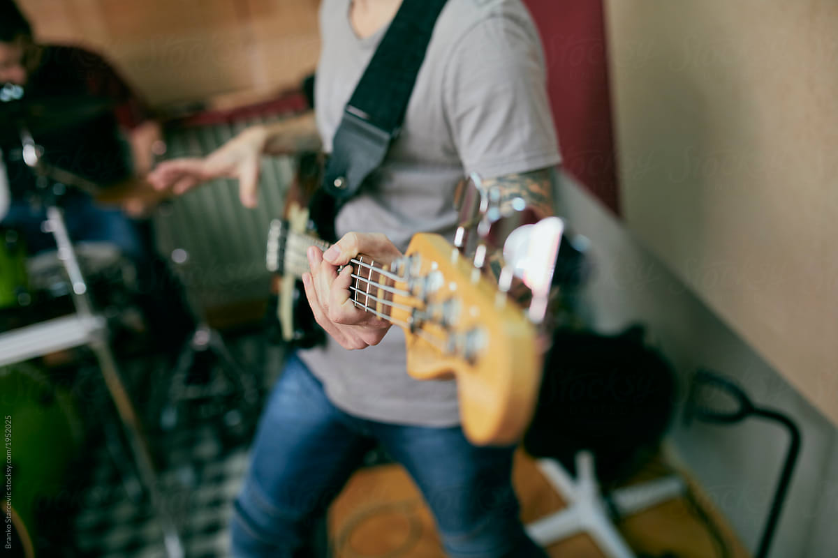 Close up of musician plays bass guitar.