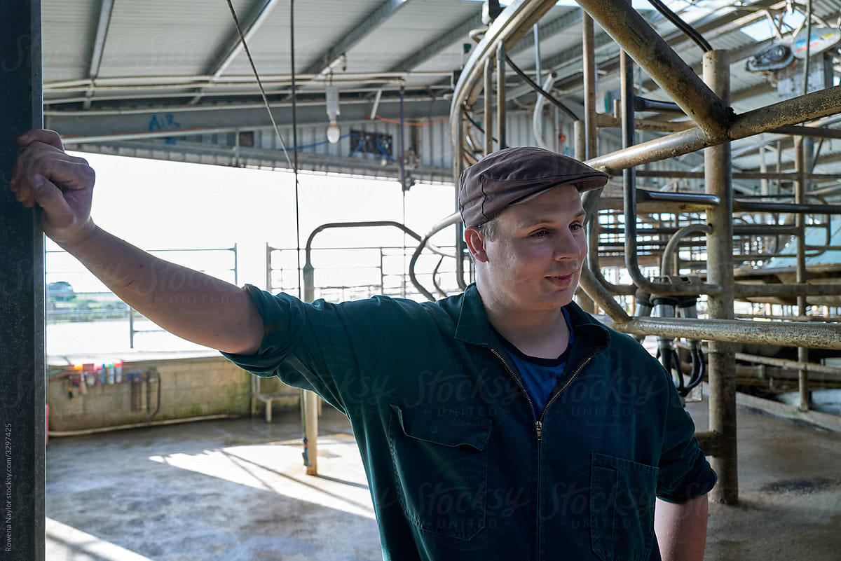 Young dairy farmer in rotary dairy