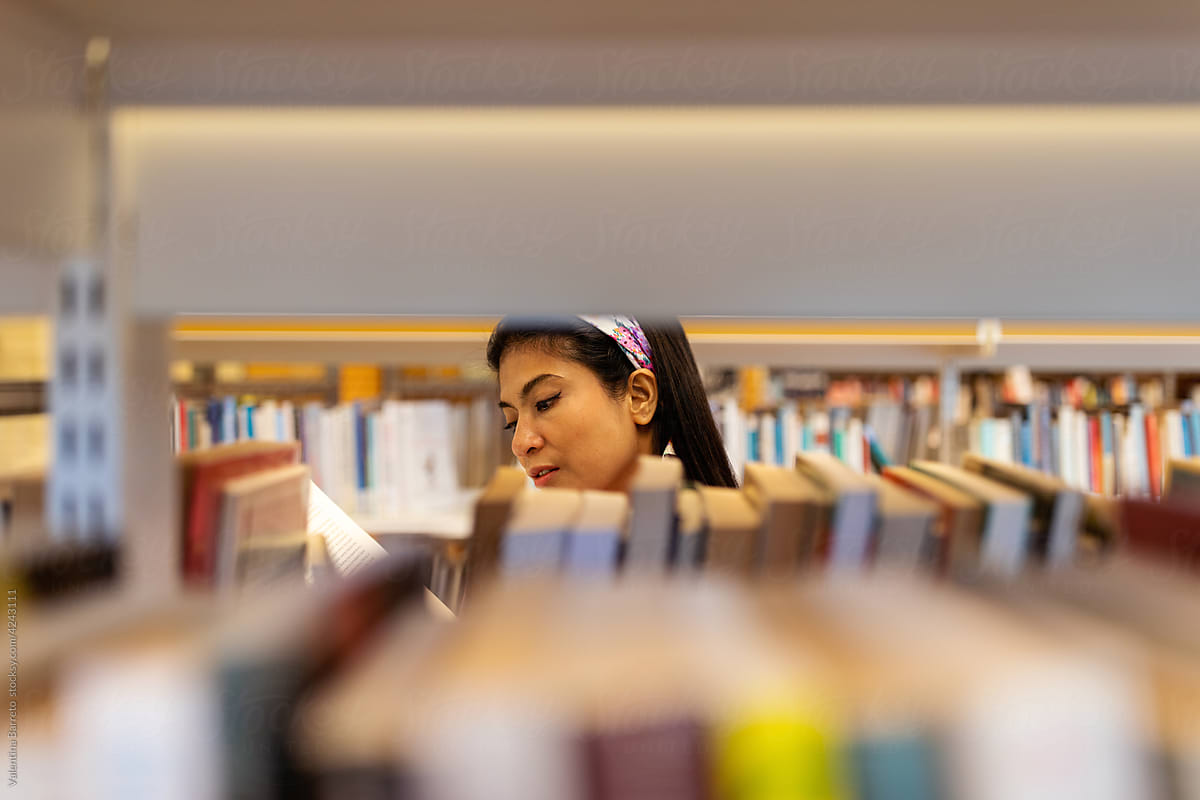 Distant woman choosing books at library