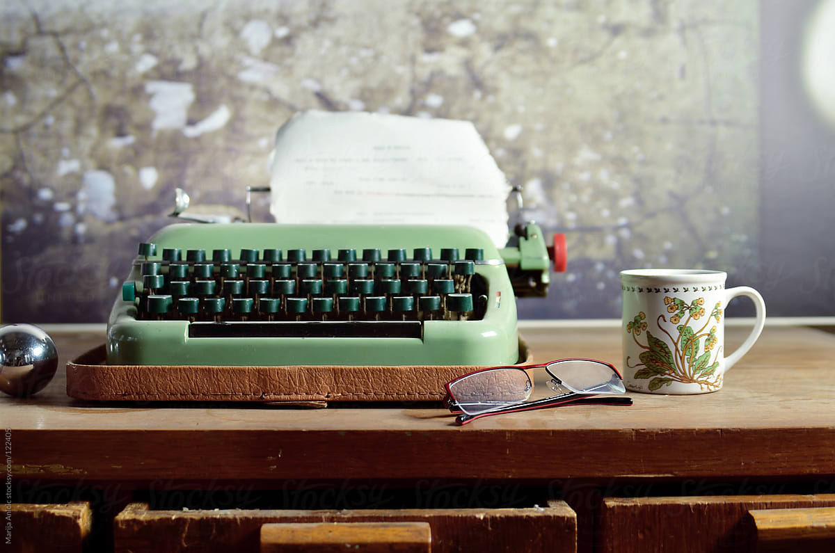 Vintage retro typewriter and cup of coffee with cookie on wooden desk