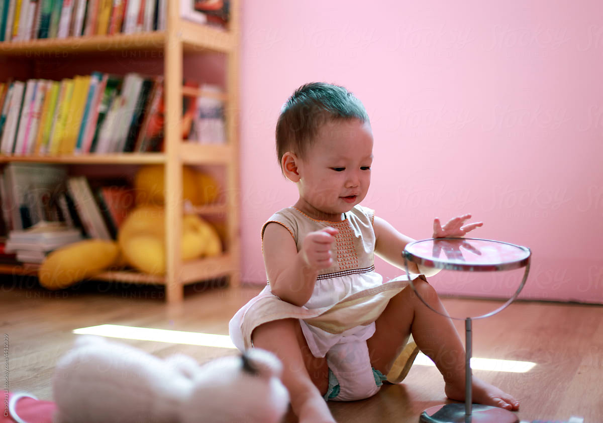 Asian baby playing with mirror