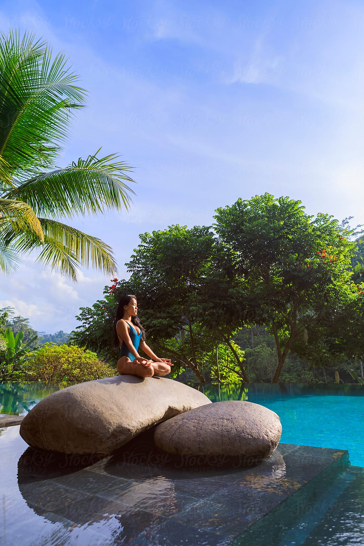 Yoga by a tropical pool setting.