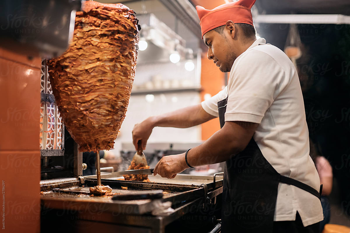 Chef cutting meat from meat roll