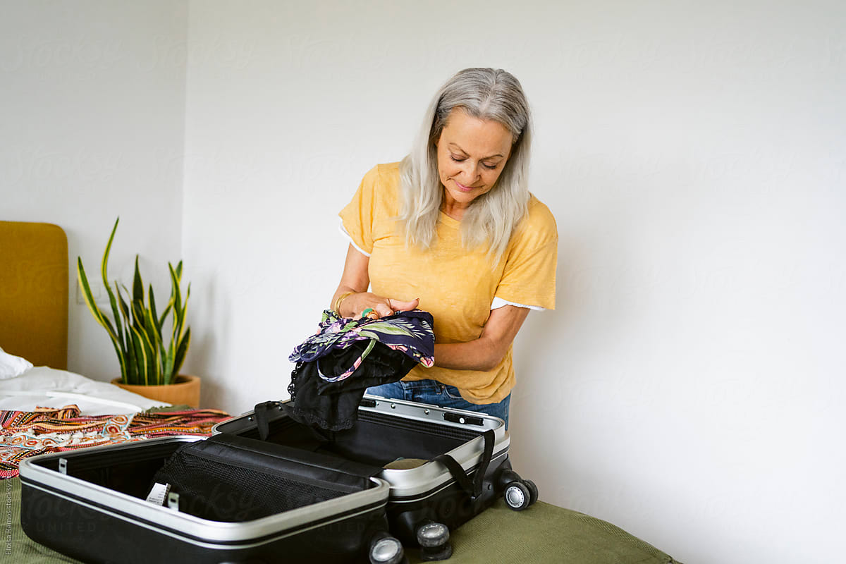 Mature woman preparing suitcase