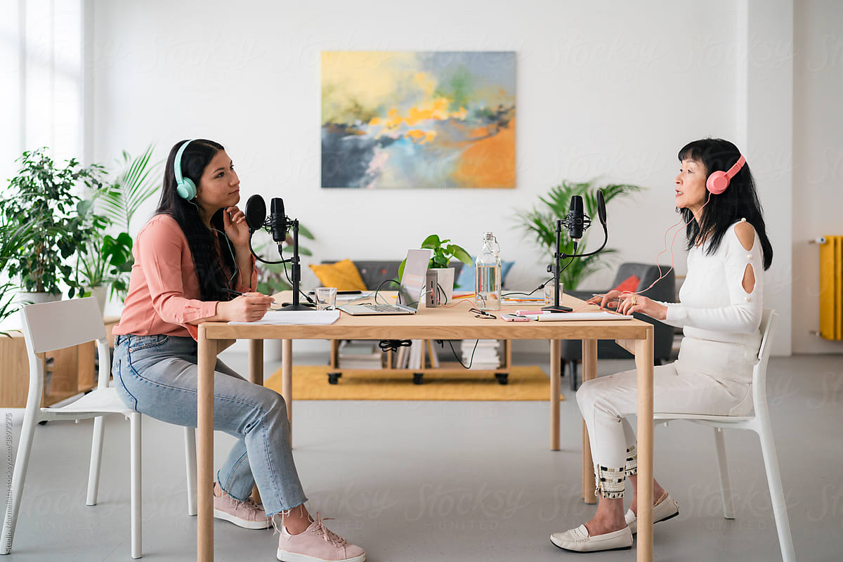 Stylish women recording podcast in open space studio