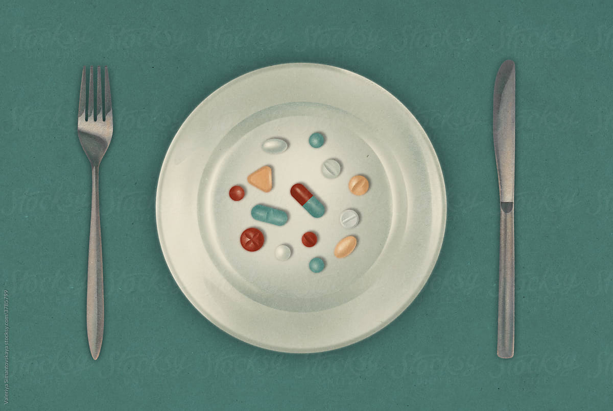Variety of pills on plate with knife and fork